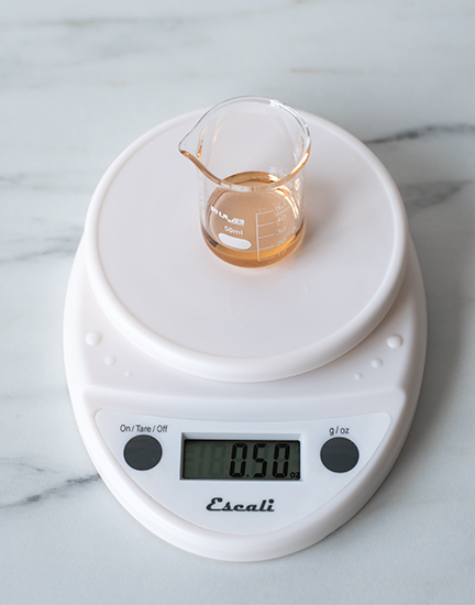 Weighing fragrance oil on a digital scale.