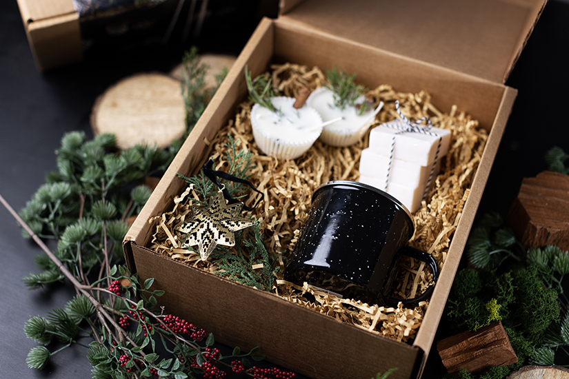 Enamel mug candle, fire starters, and all-in-one shampoo and body bar gift box.