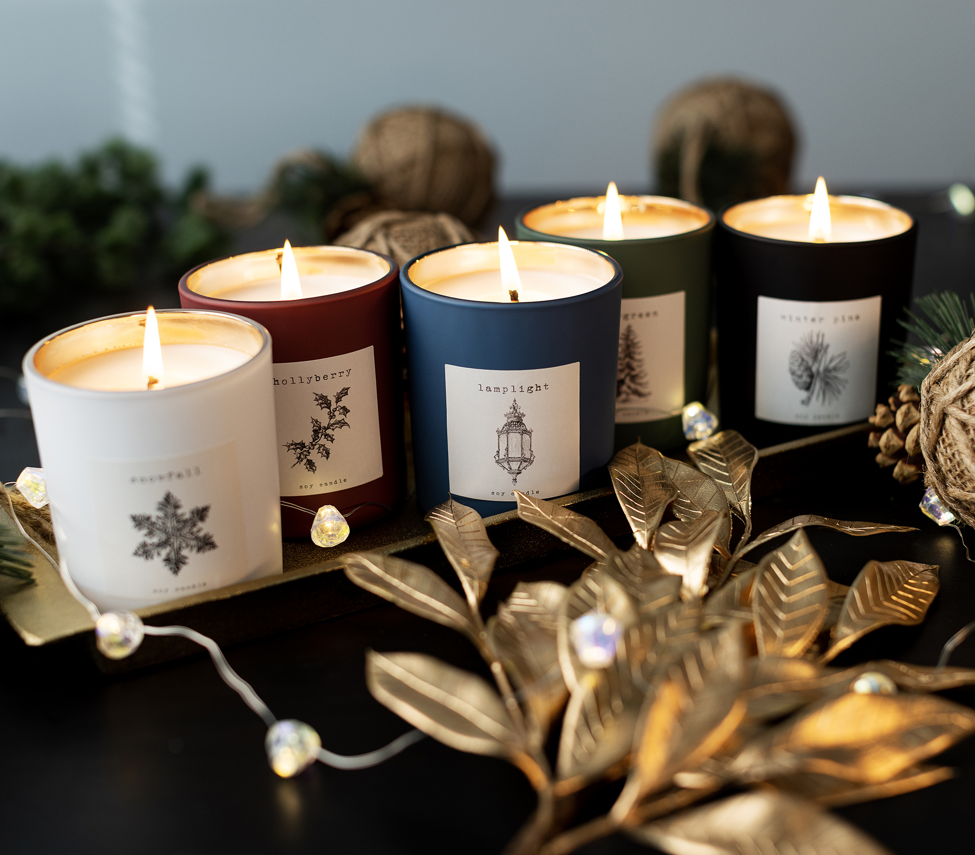 Matte tumbler jar candles lit with holiday inspired labels.