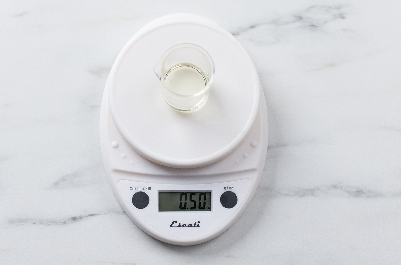 Weighing fragrance oil on a digital scale.