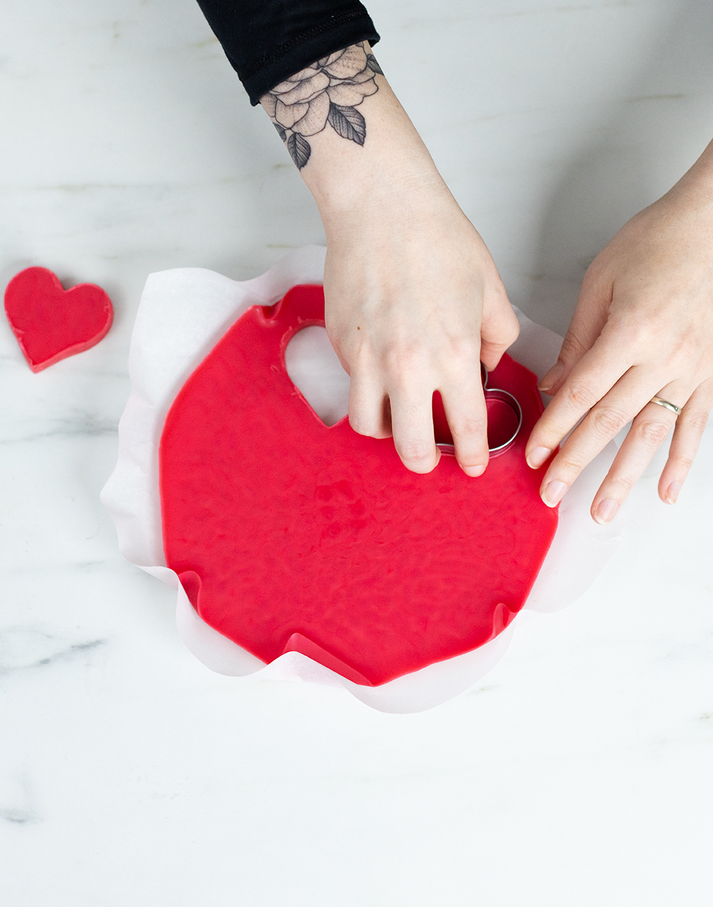 Cutting hearts out of red wax.