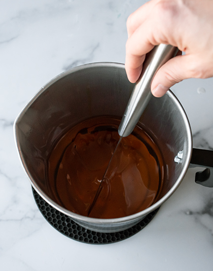 Stirring fragrance oil into melted soy wax.