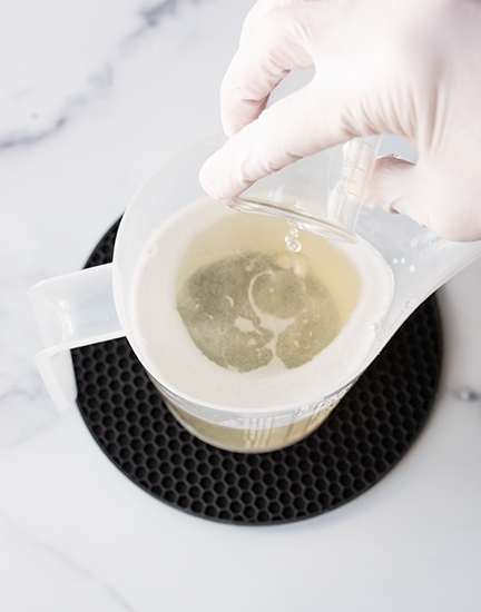 Pouring essential oil in melted soap.