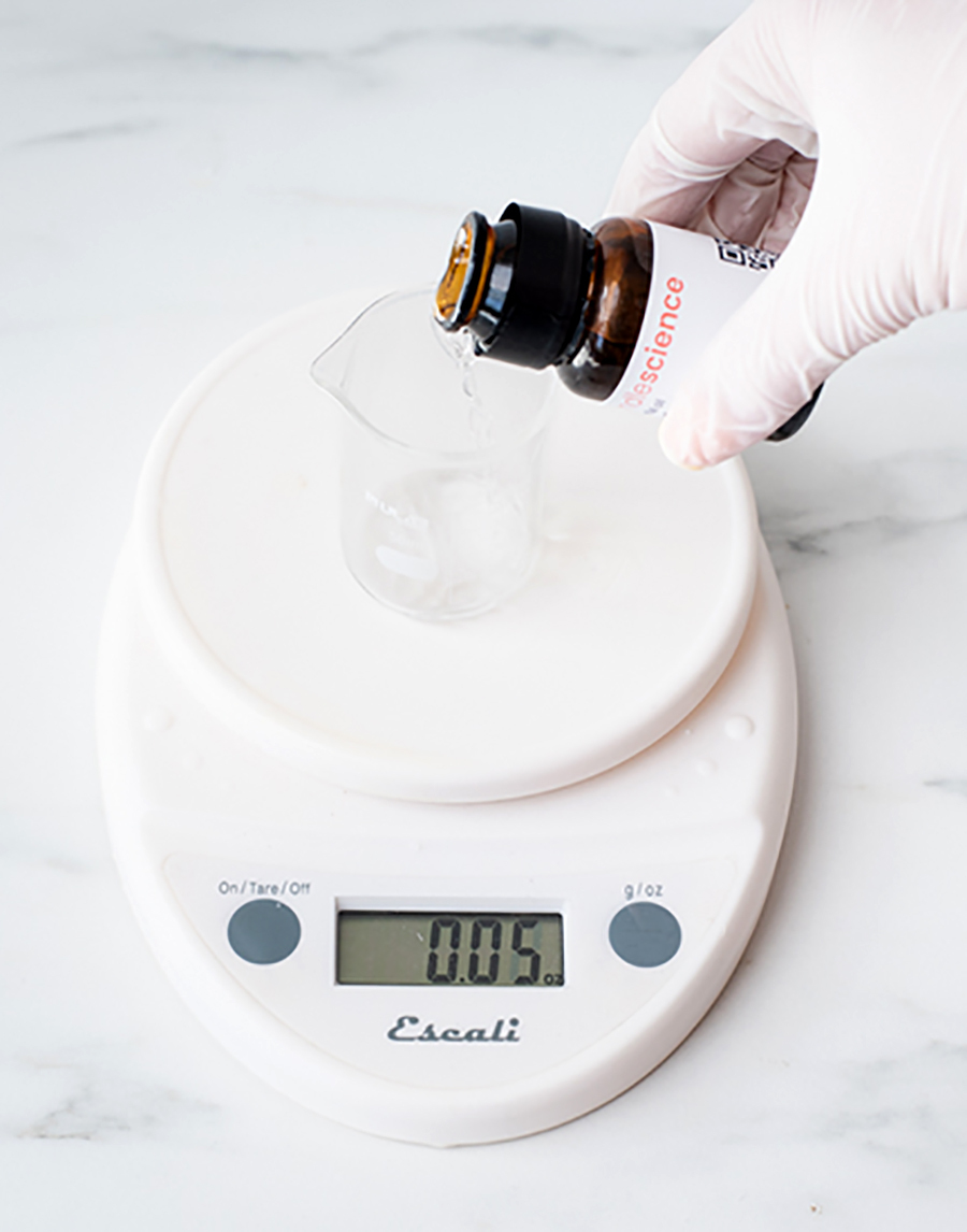 Pouring essential oil into beaker.