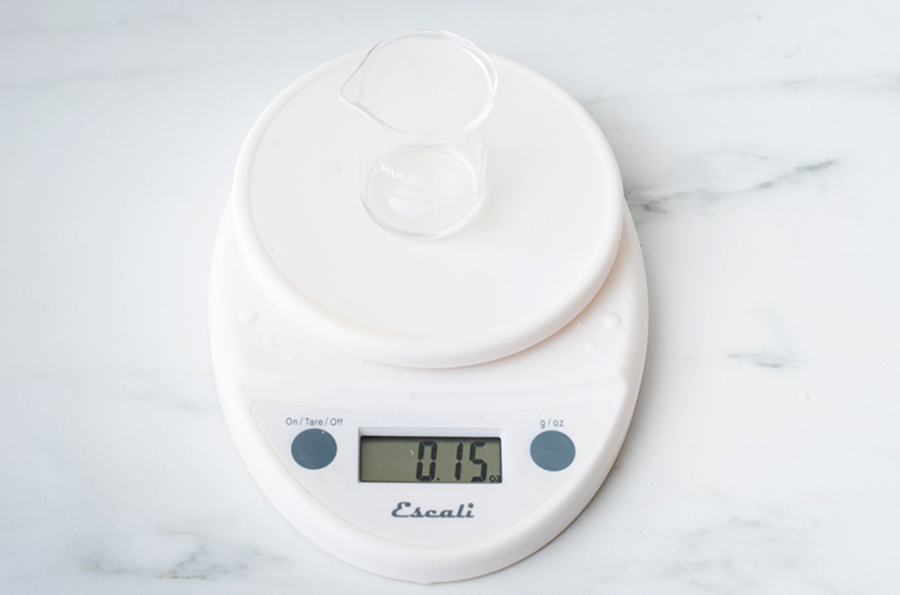 Essential oil in a beaker on a digital scale.