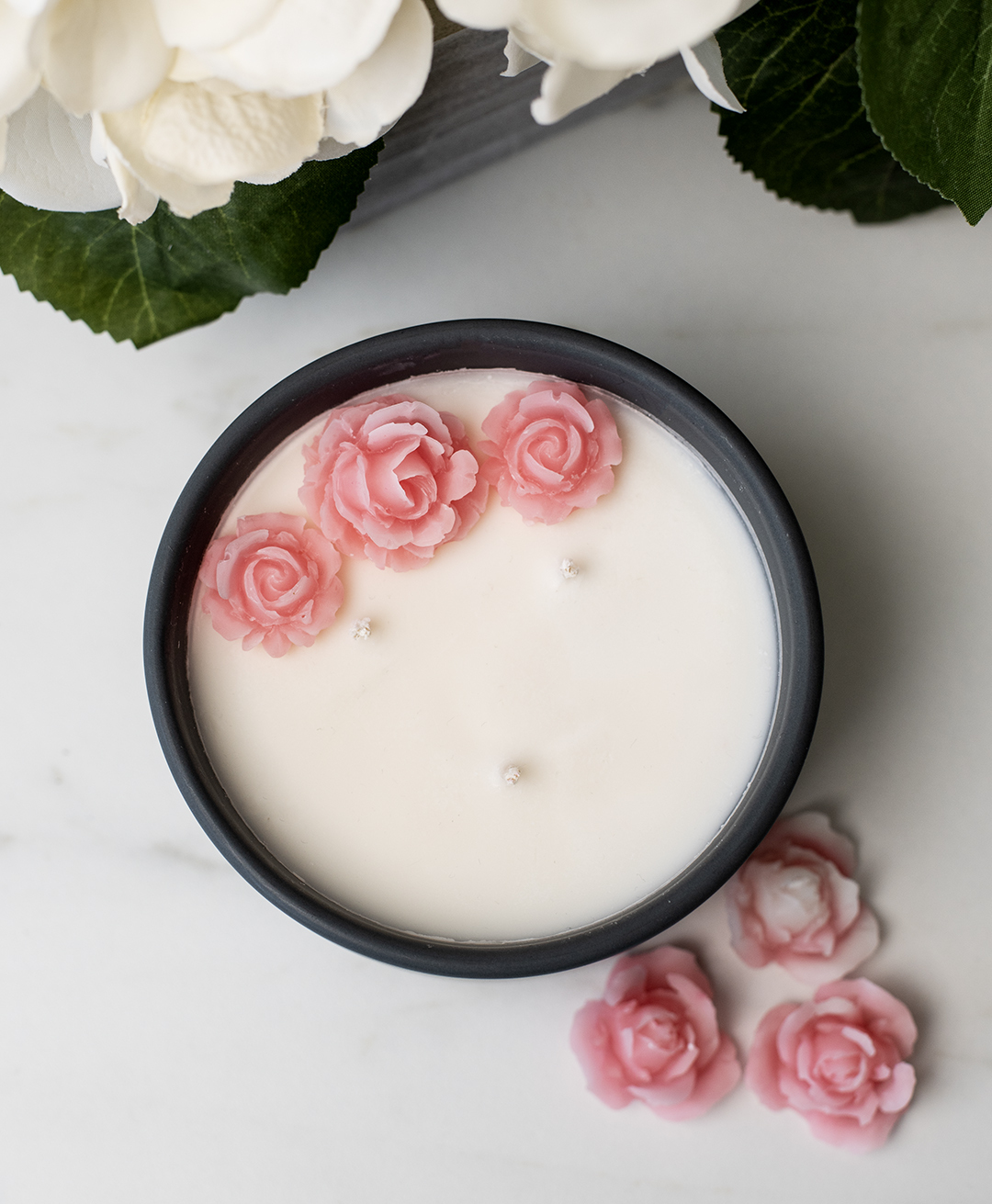 Candle with flower wax embeds on top.