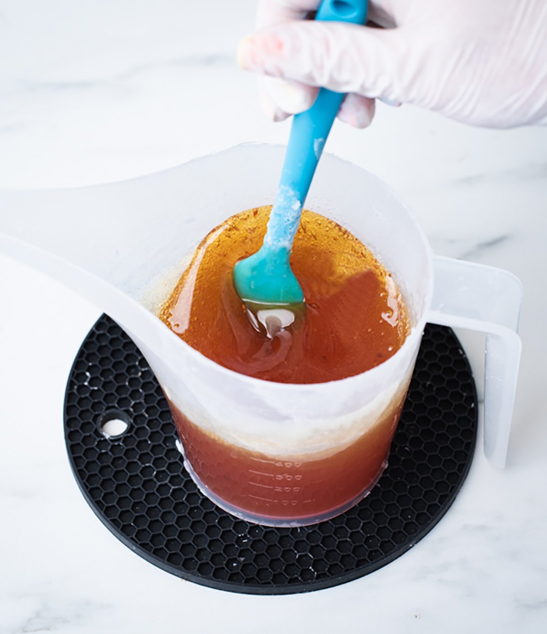 Stirring turmeric into melted soap base.