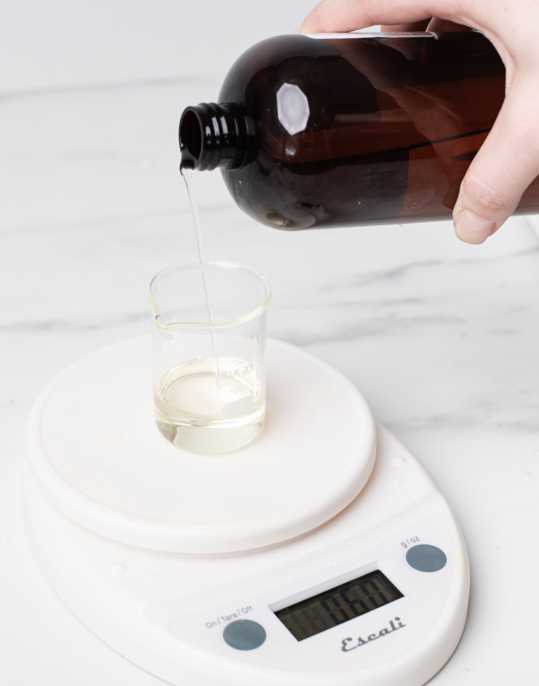 Weighing fragrance oil on a digital scale.