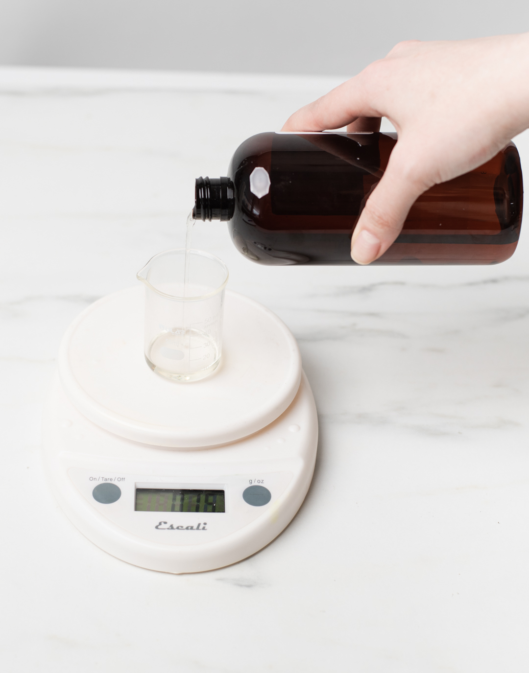 Pouring essential oil into beaker.