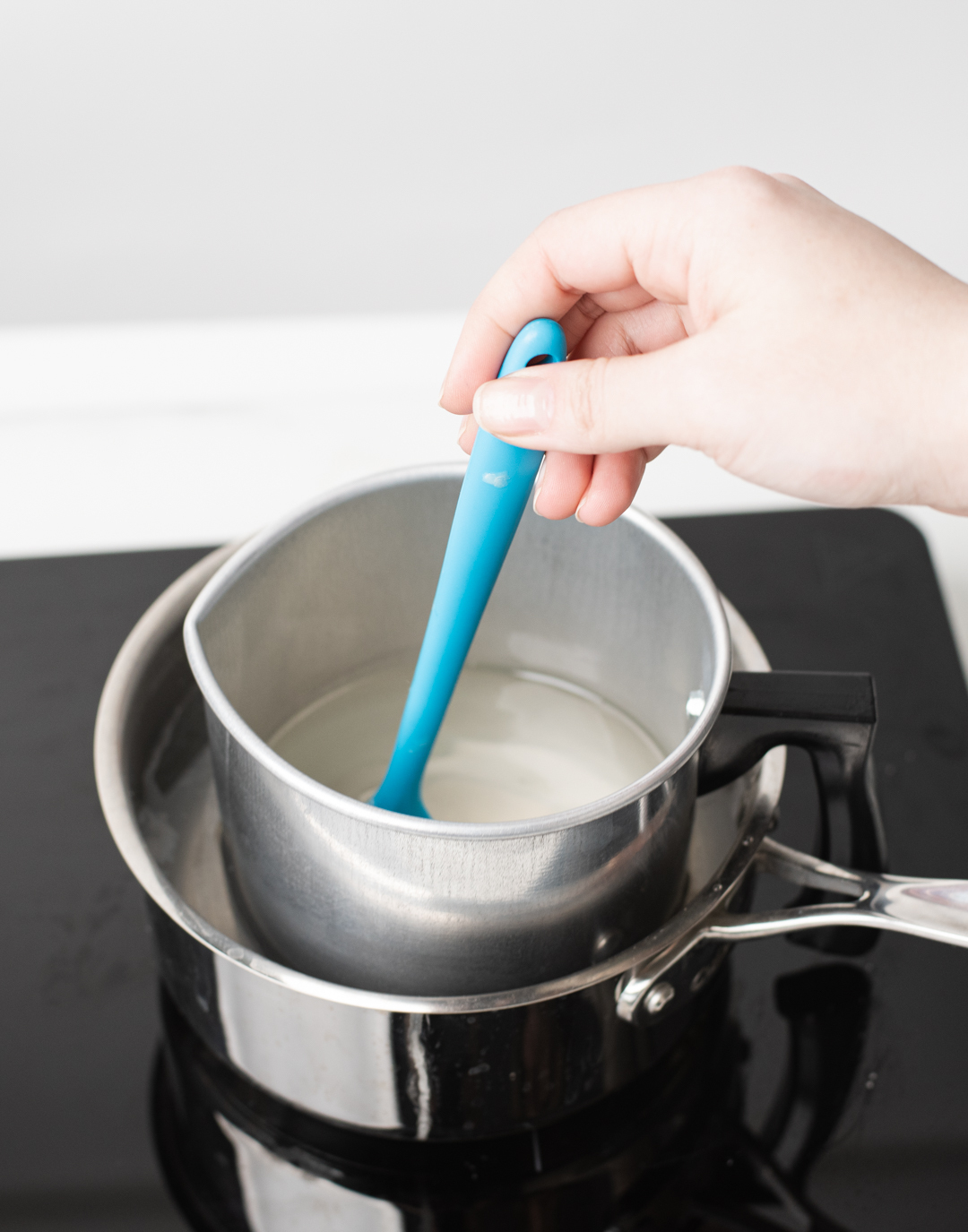 Stirring fragrance oil into melted wax.