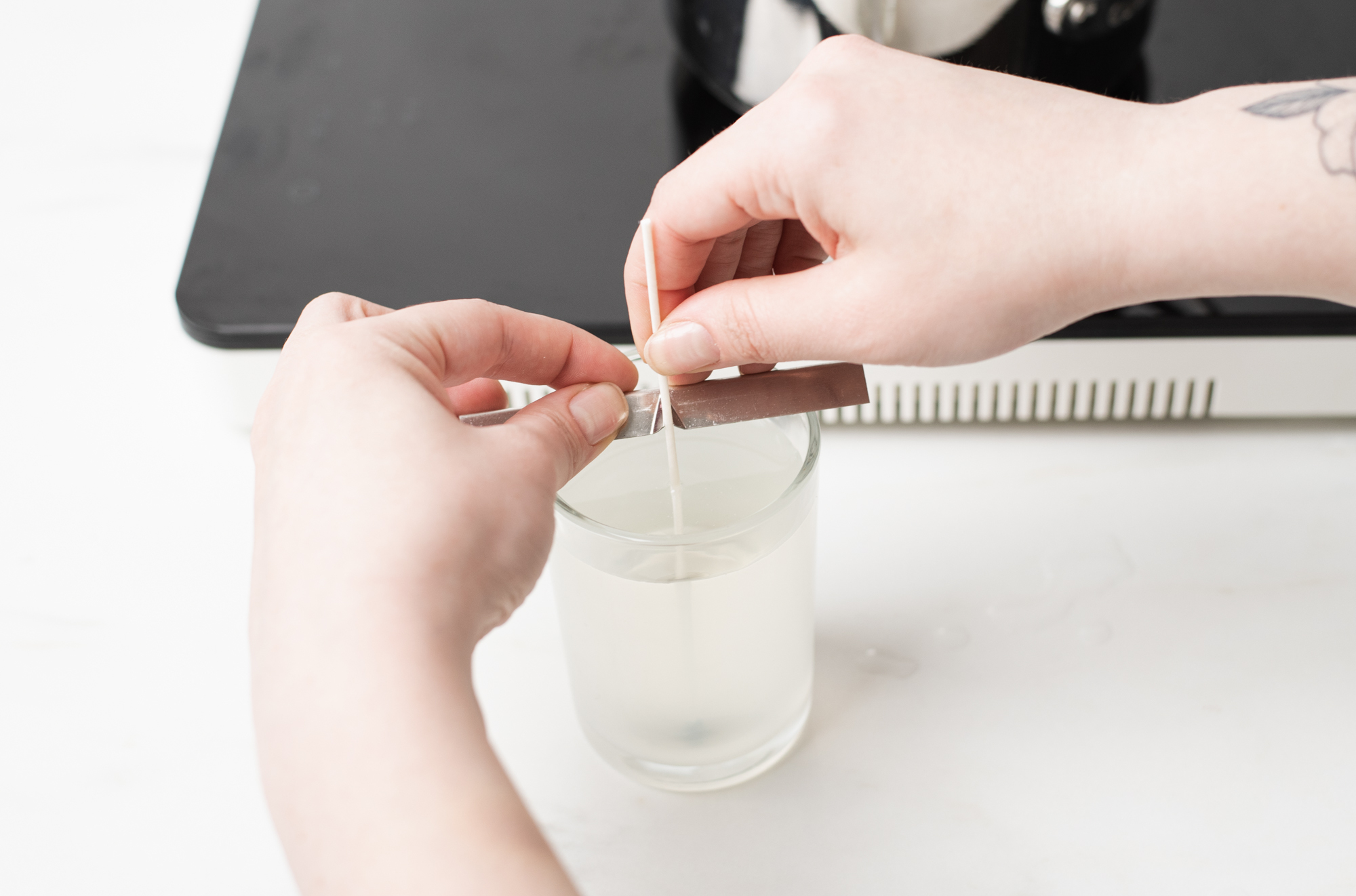 Adding a wick bar to a cooling candle.