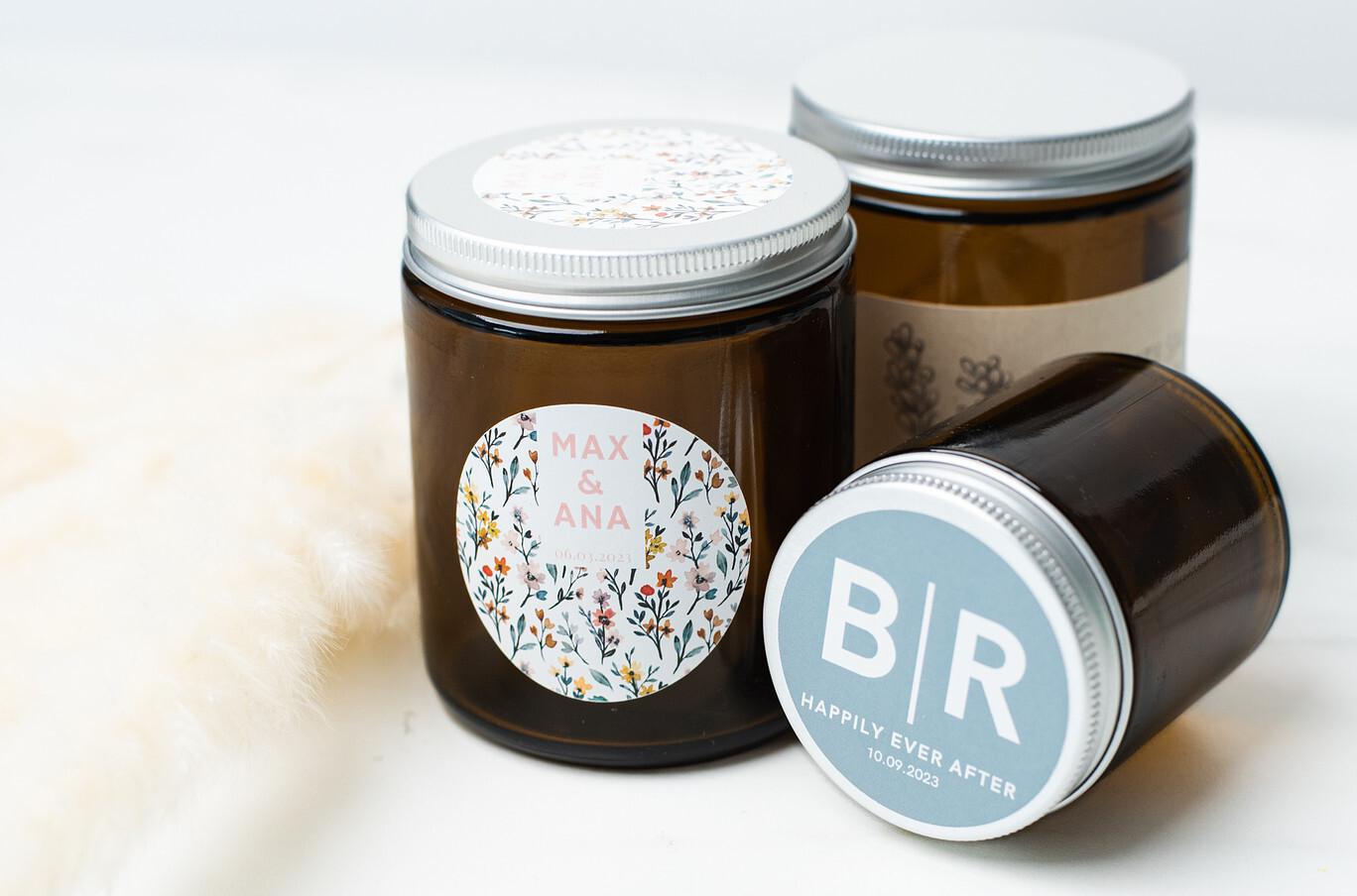 Three candles in amber glass jars and silver lids