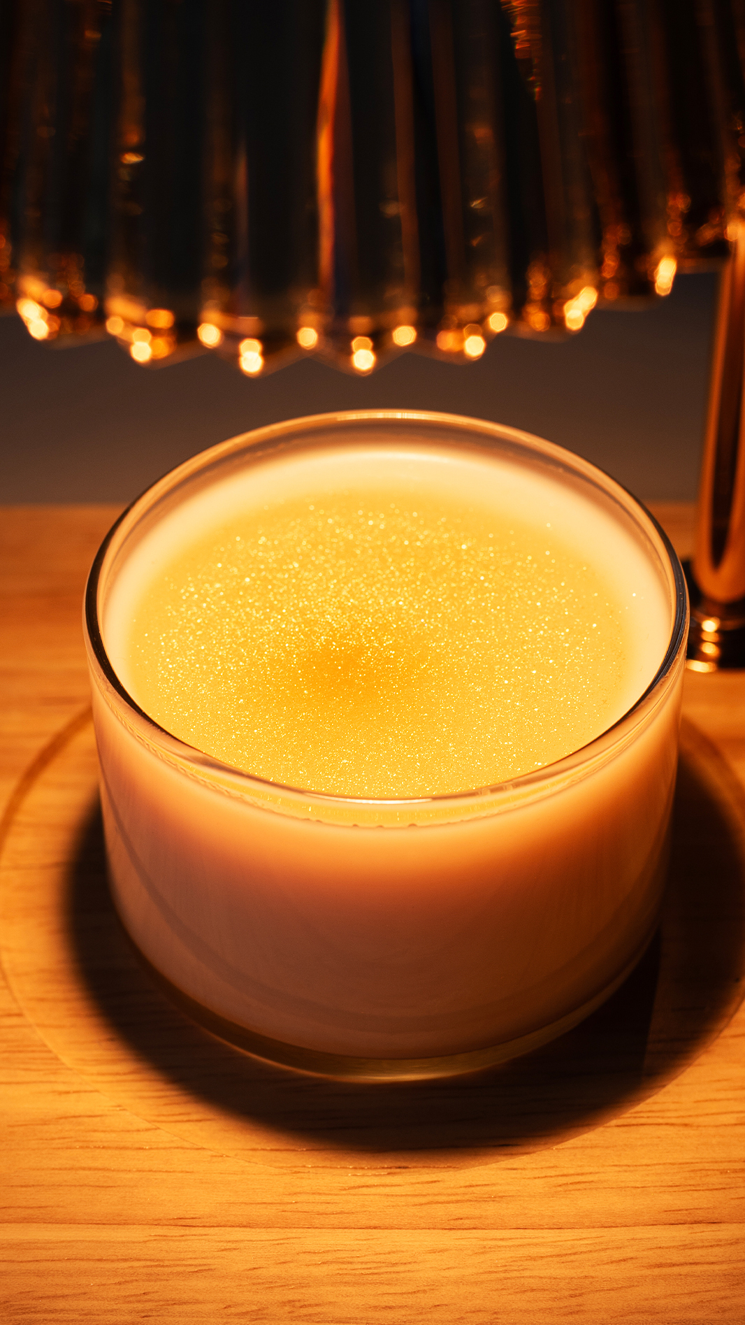 A wickless candle sparkling with mica under candle warmer light.