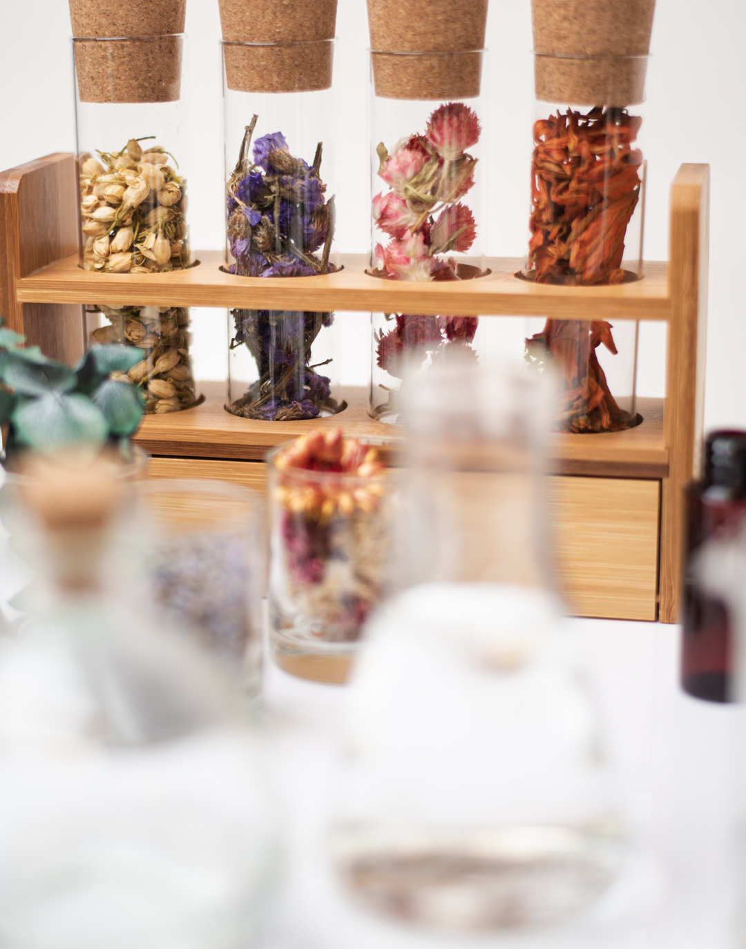 Test tubes with cork stoppers are filled with dried flowers and other fragrance ingredients.