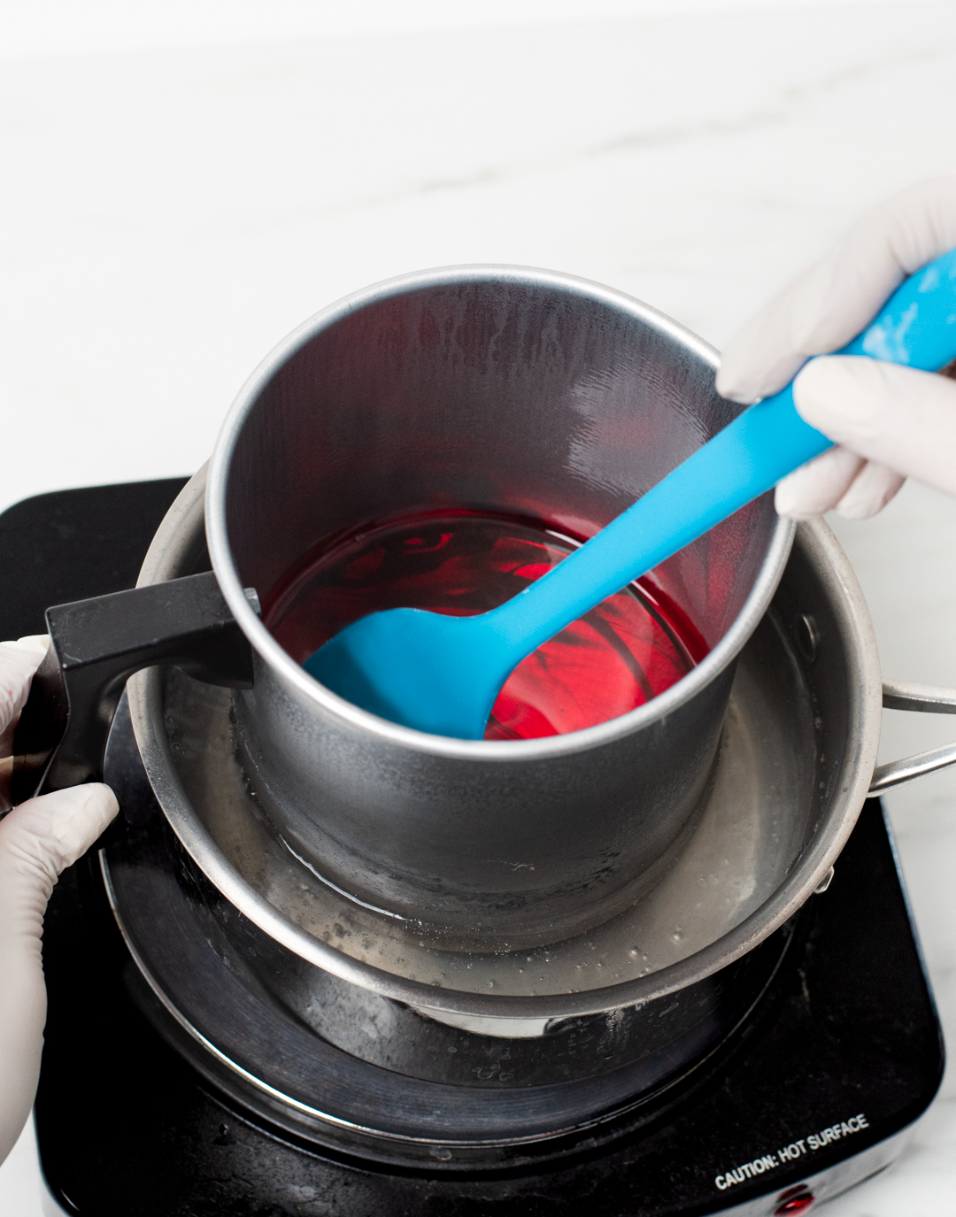 Stirring dye block into melted wax.