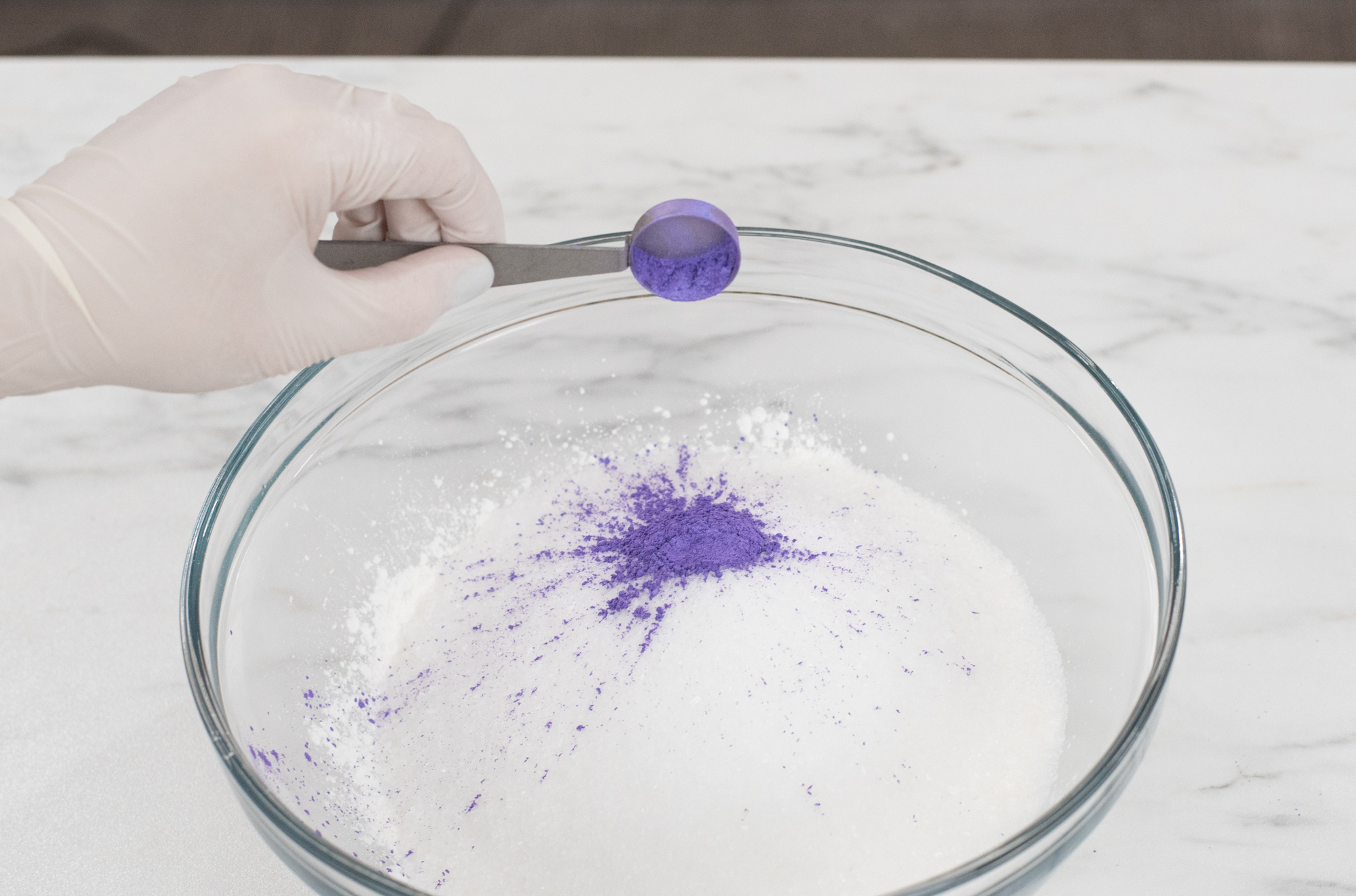 Adding mica to bowl of bath bomb ingredients.