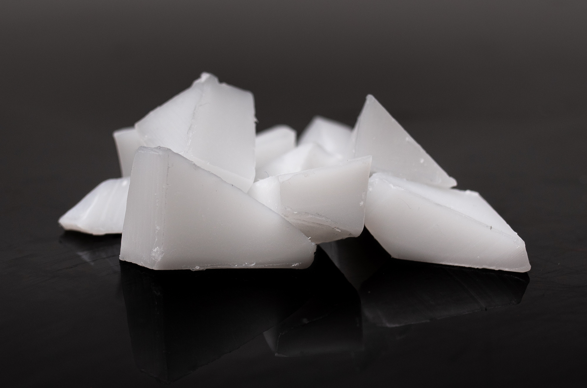 Sharp-cornered slices of paraffin wax. The wax is whiteish and slightly transparent. 