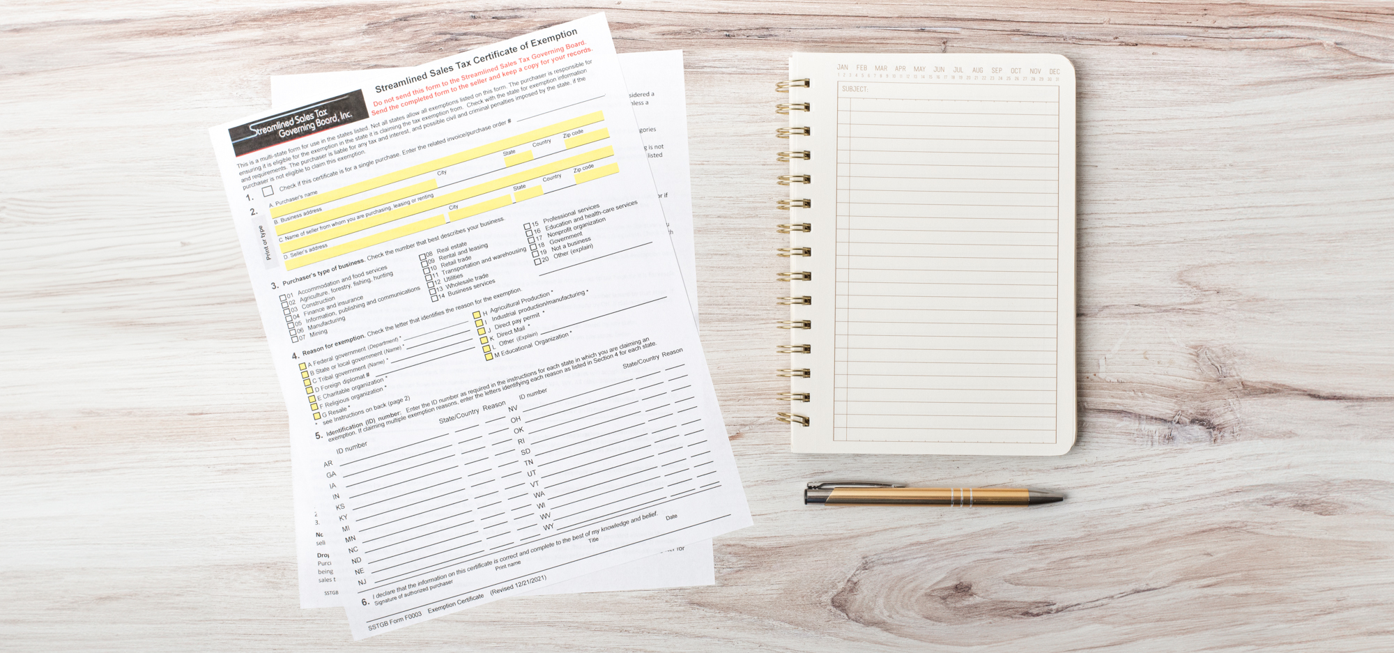 A printout of the Streamlined Sales Tax Certificate of Exemption sits on a desk next to a notebook and pen.