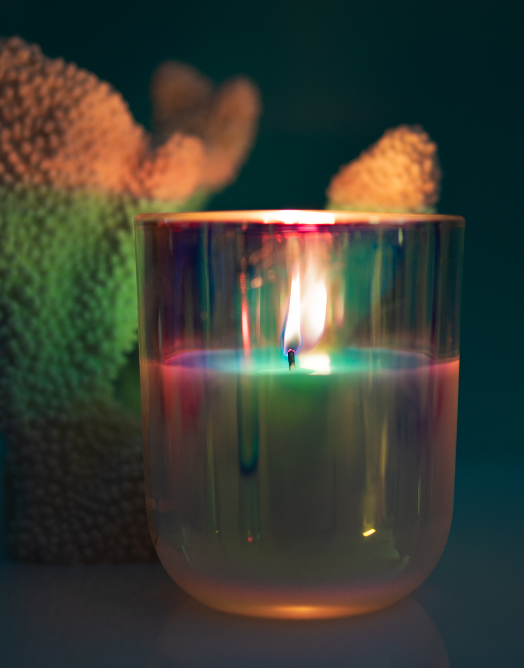 A candle burning and lighting the candle container creating a glow.