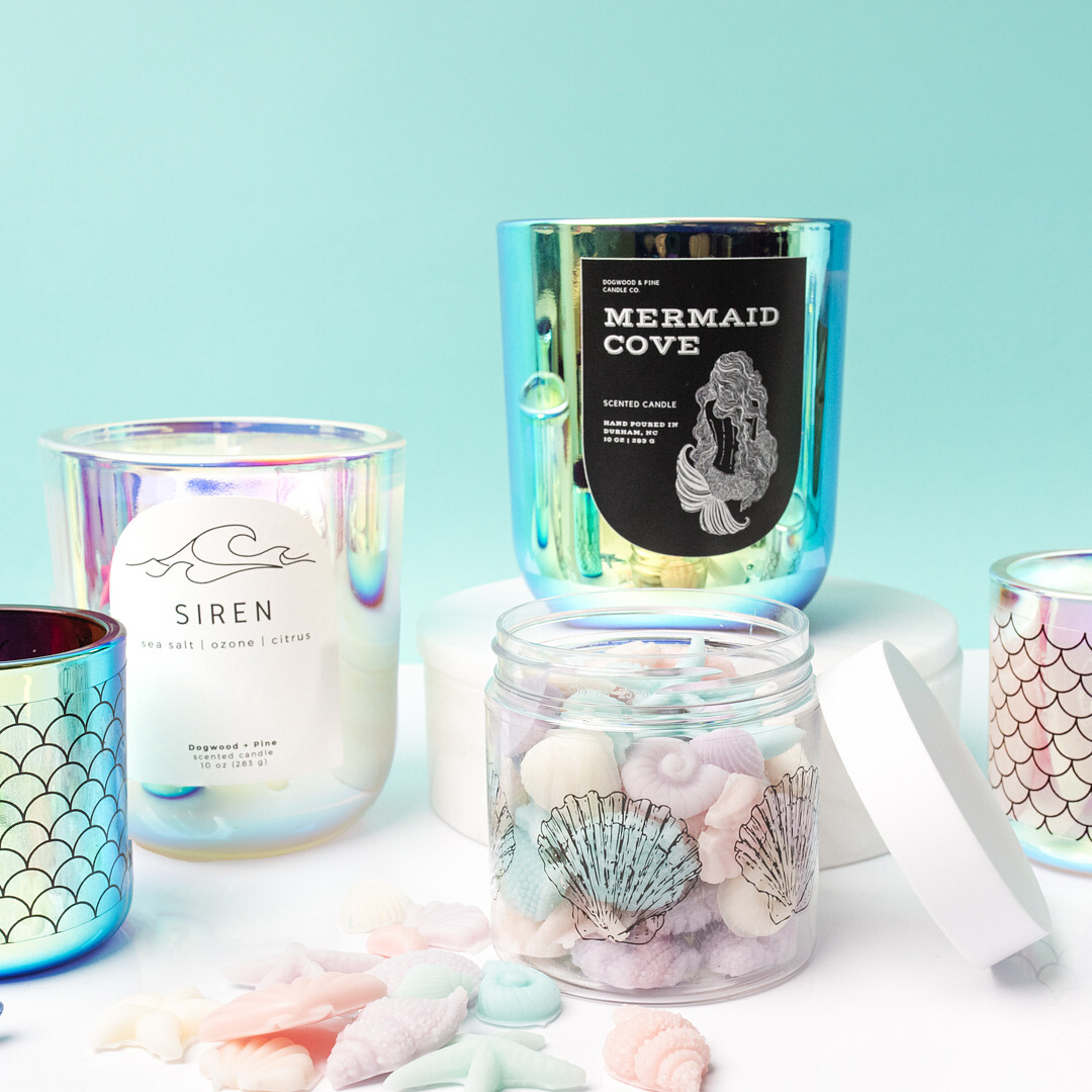 Mermaid-themed candles in iridescent glass jars and seashell-shaped wax melts