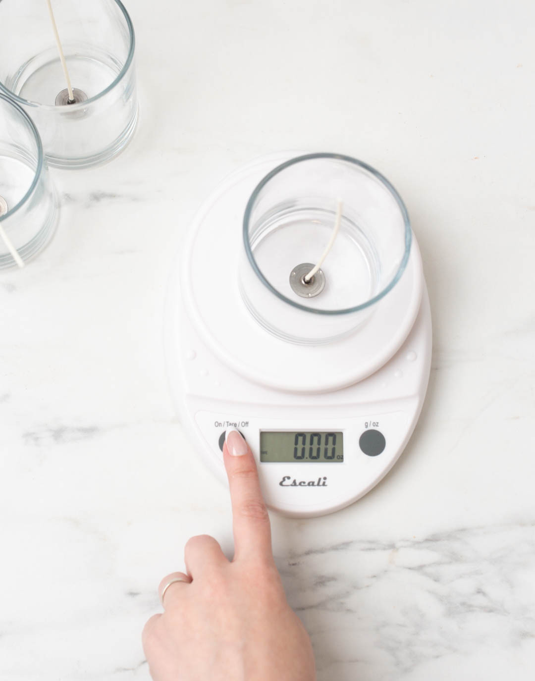 Taring a scale with a container on it for candle making.