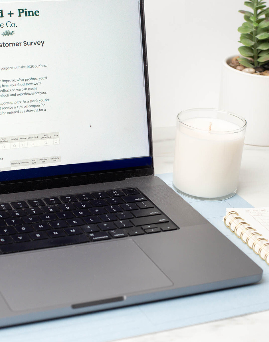 A close-up of a laptop displaying a wholesale customer survey from Dogwood + Pine Candle Co.