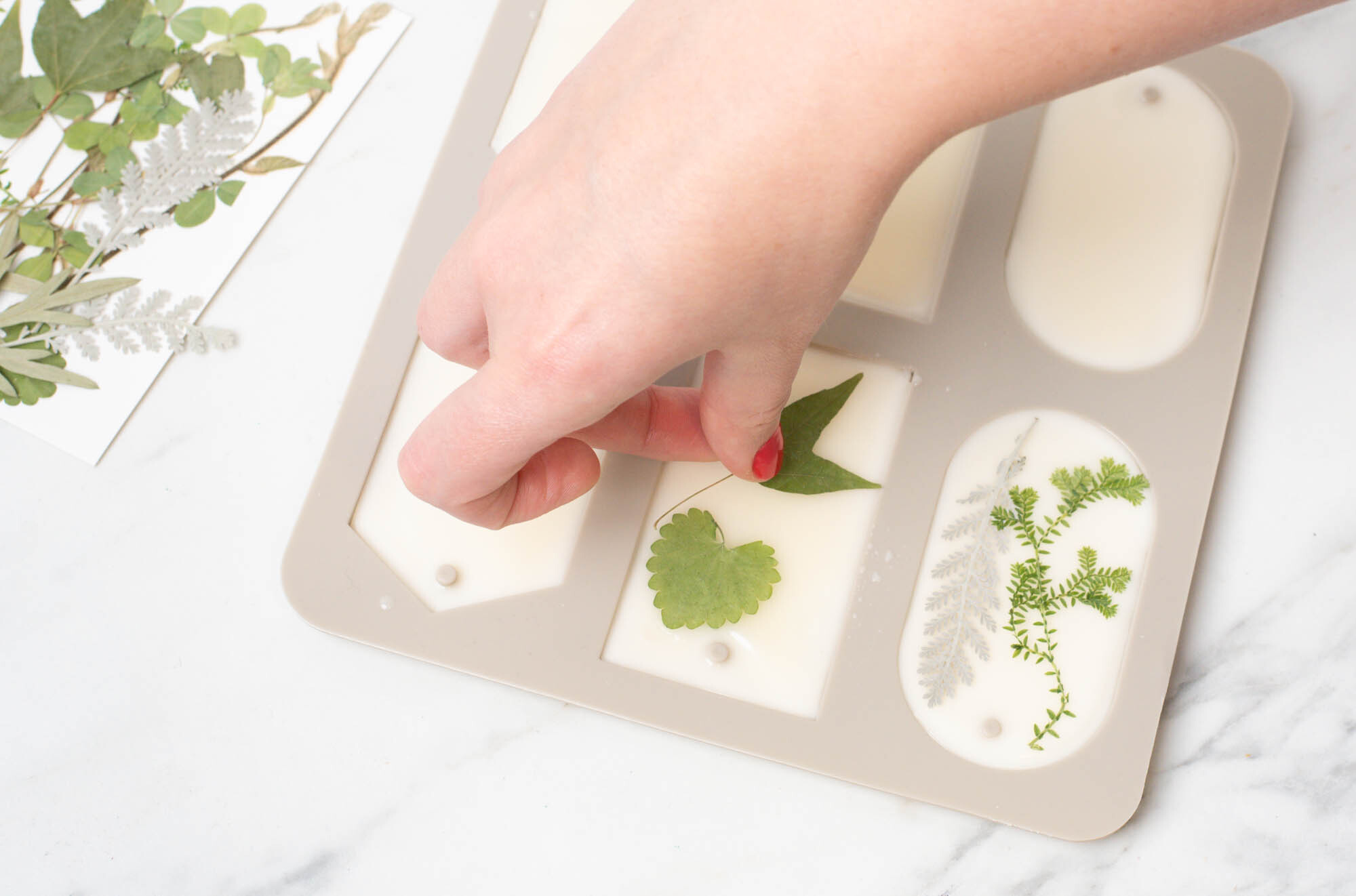 Pressing botanicals into wax sachets.