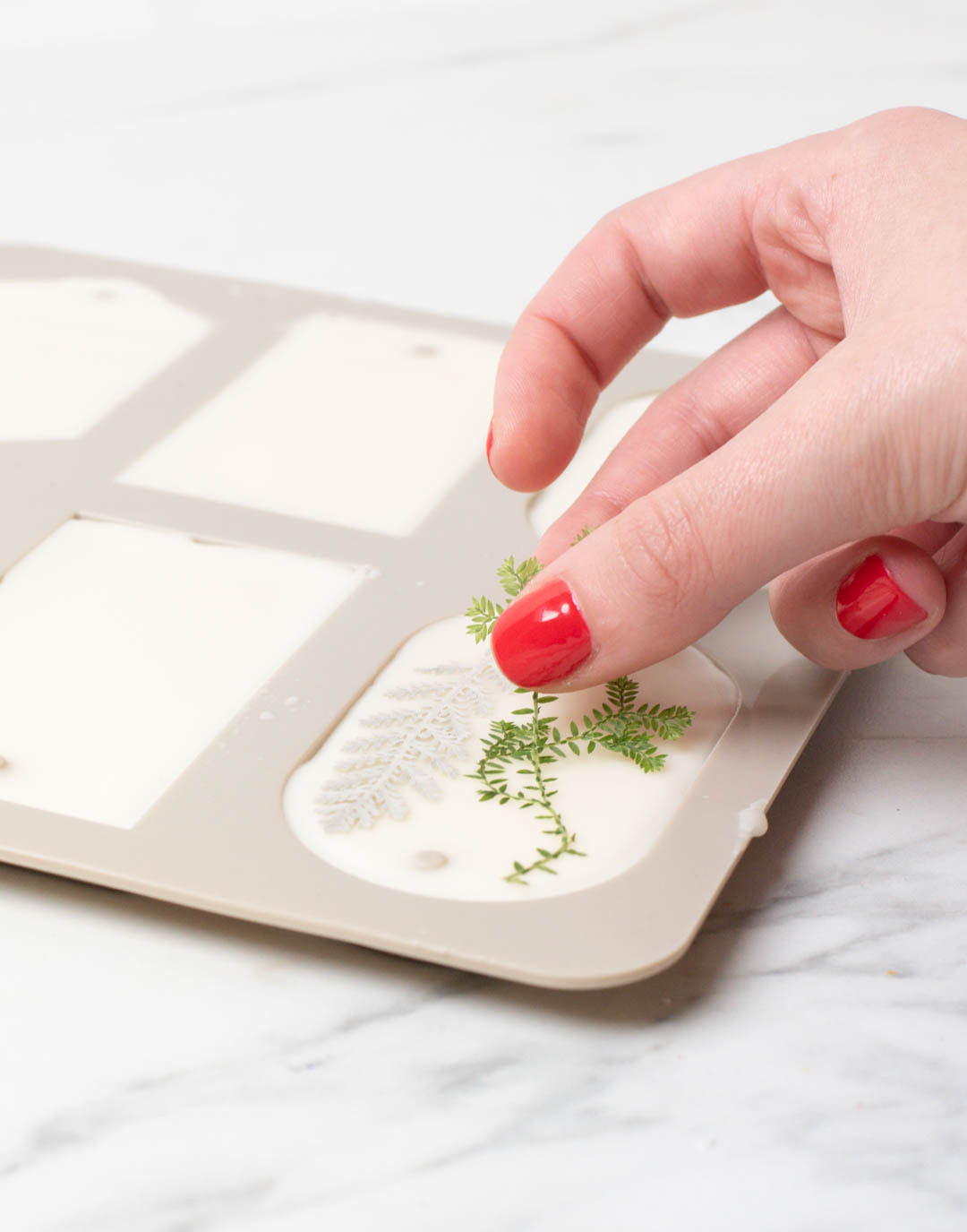 Pressing botanicals into wax sachets.