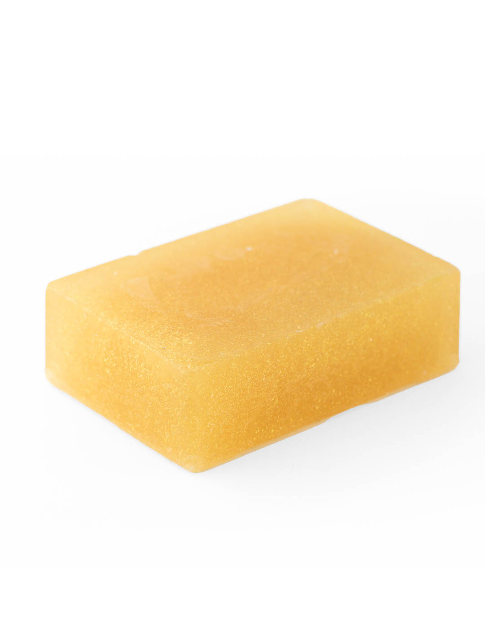 A bar of gold, shimmery, mica-colored melt and pour soap against a white background. 