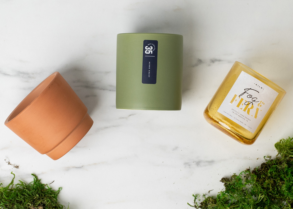 terracotta pot, sage modern ceramic, and yellow bubble tumbler with moss on a marble table