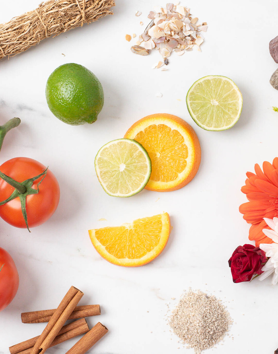 Natural elements like orange slices, limes, tomato, cinnamon sticks, flowers, and botanicals that can be used in candle and soap product photos