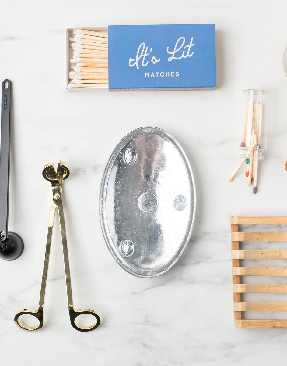 Accessories like matches, a wick trimmer, and a wooden soap dish that can be used in candle and soap product photos