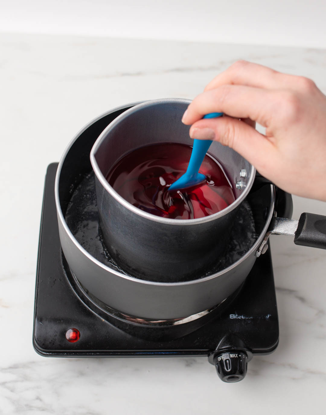 Stirring fragrance oil into melted soy wax.