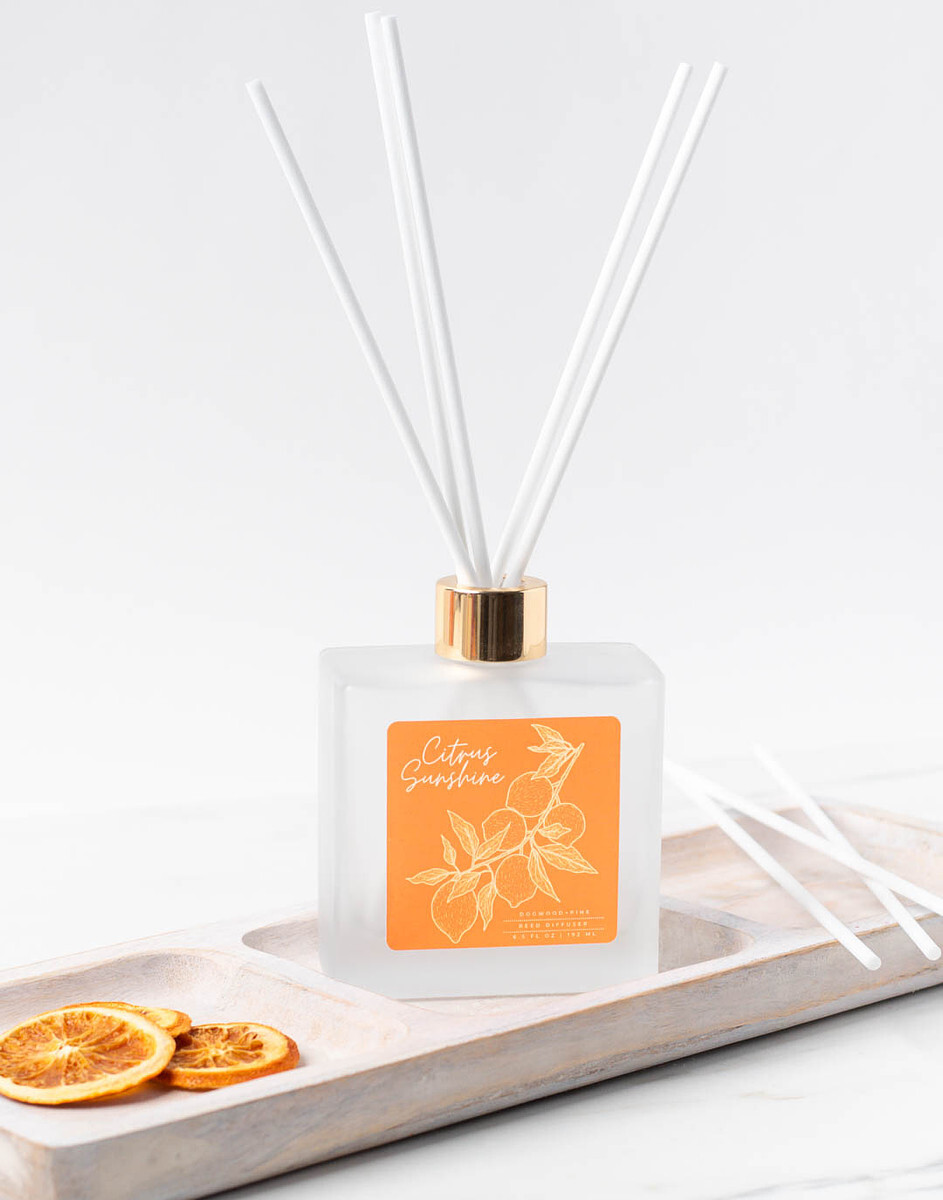 Citrus Sunshine reed diffuser in a frosted glass bottle with gold collar and white fiber reeds