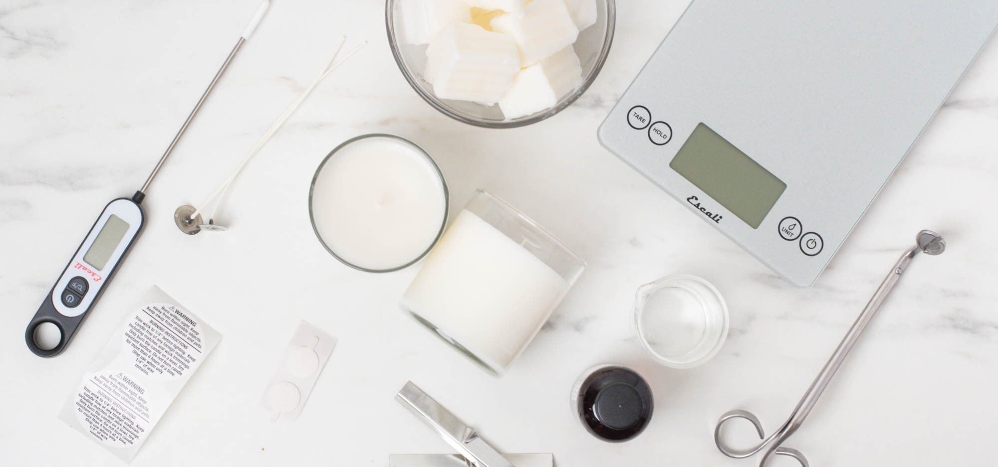 An image of tools and materials needed to make two scented candles.