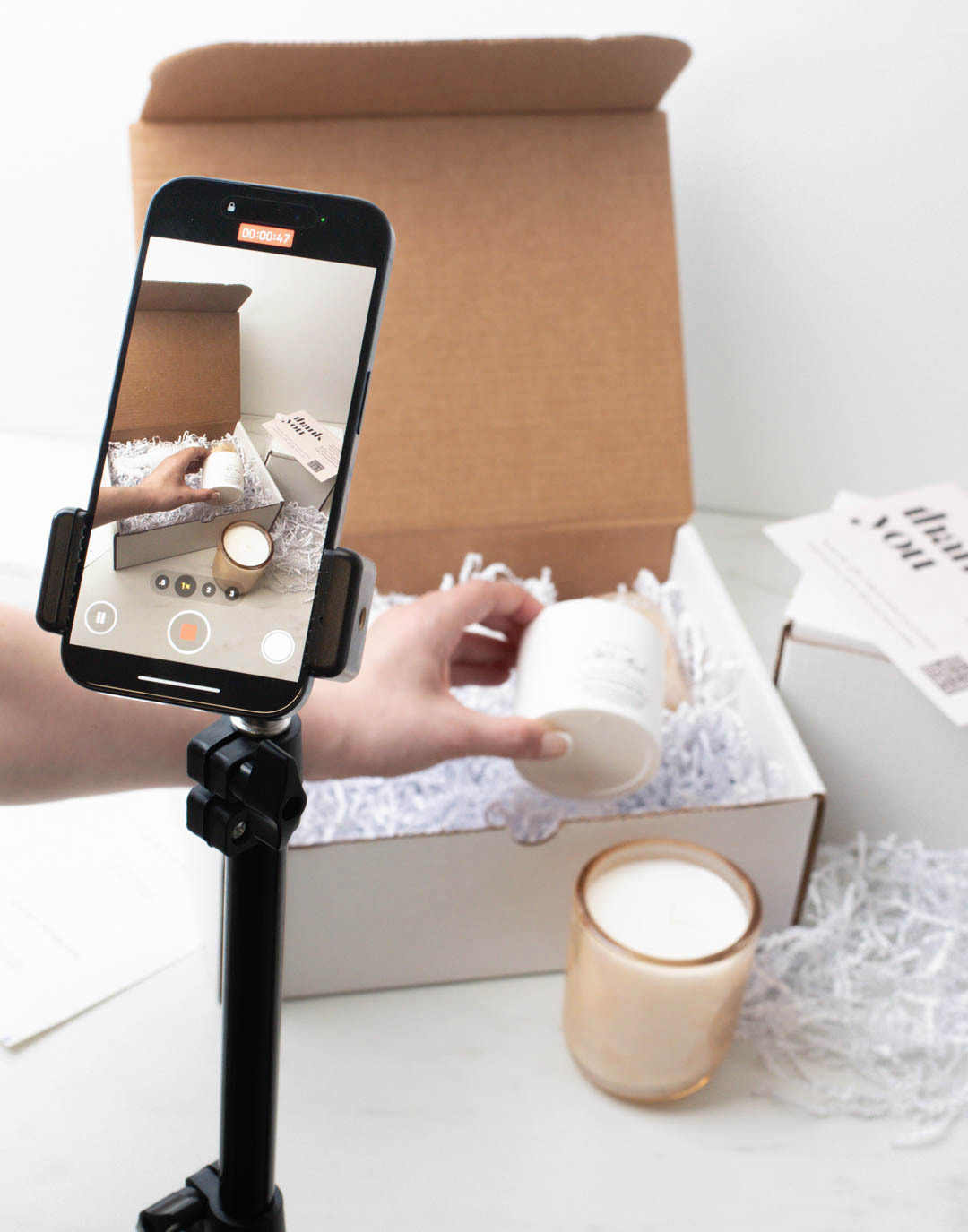 A tripod holding a cell pone records an unboxing experience 