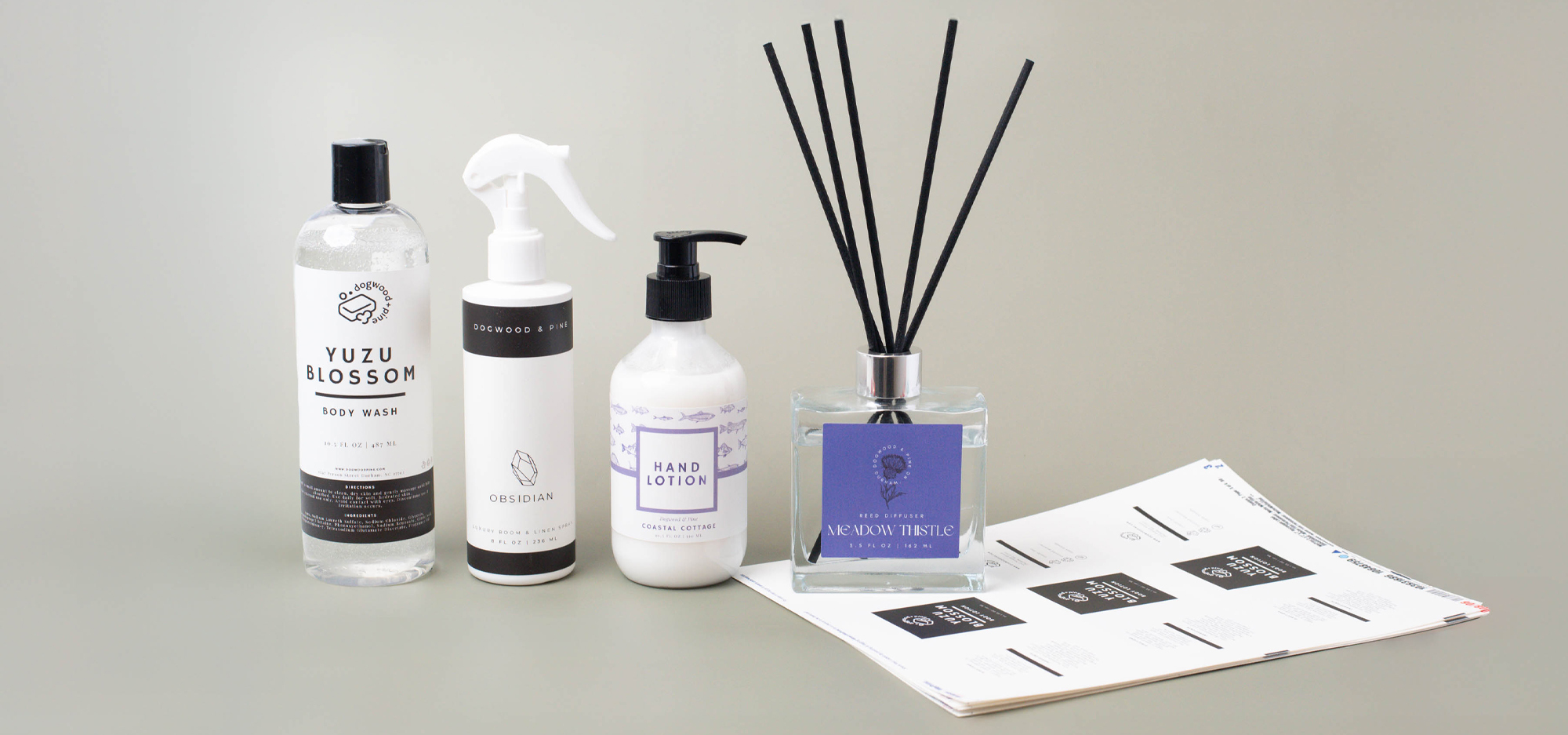 A group of labeled liquid products including body wash, room spray, lotion, and a reed diffuser.