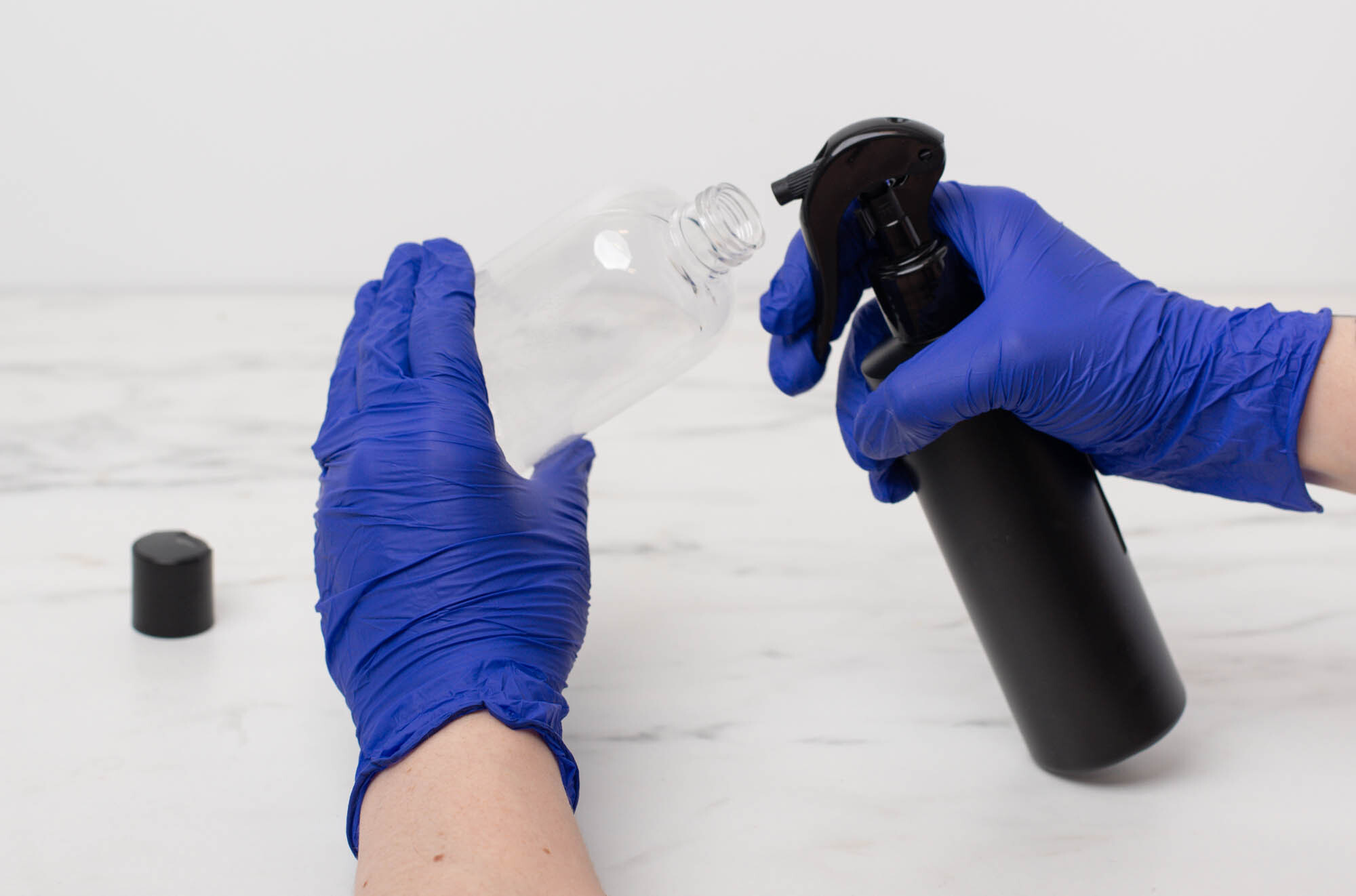 Pouring fragrance oil into a glass beaker on a scale.