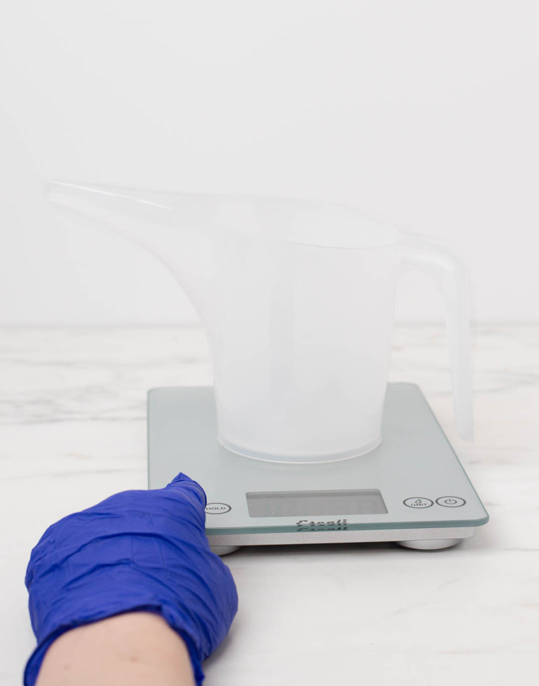 Pouring diffuser base into a funnel pouring pitcher on a scale.