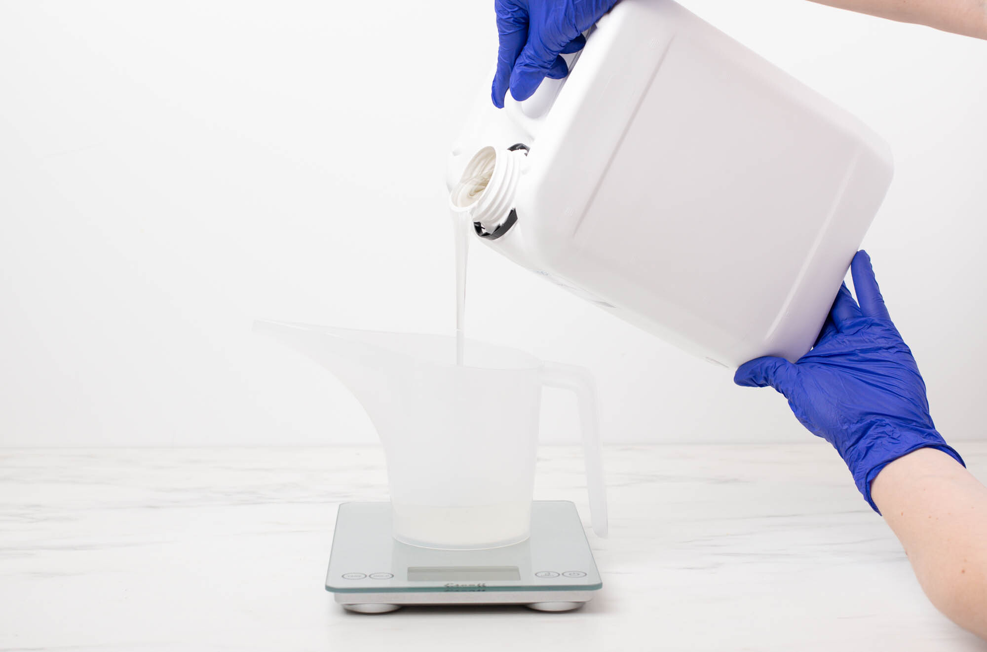 Diffuser base in a funnel pouring pitcher on a scale reading 4.5 ounces.
