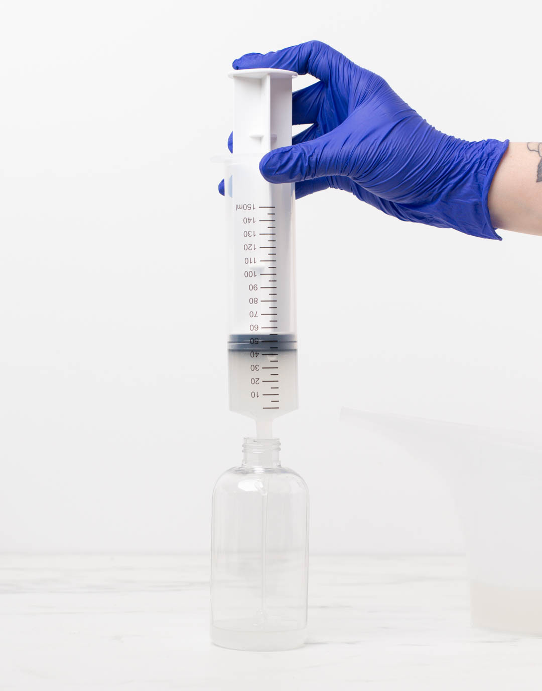 Hand tilting diffuser bottle with collar and stopper to show that it will not leak.