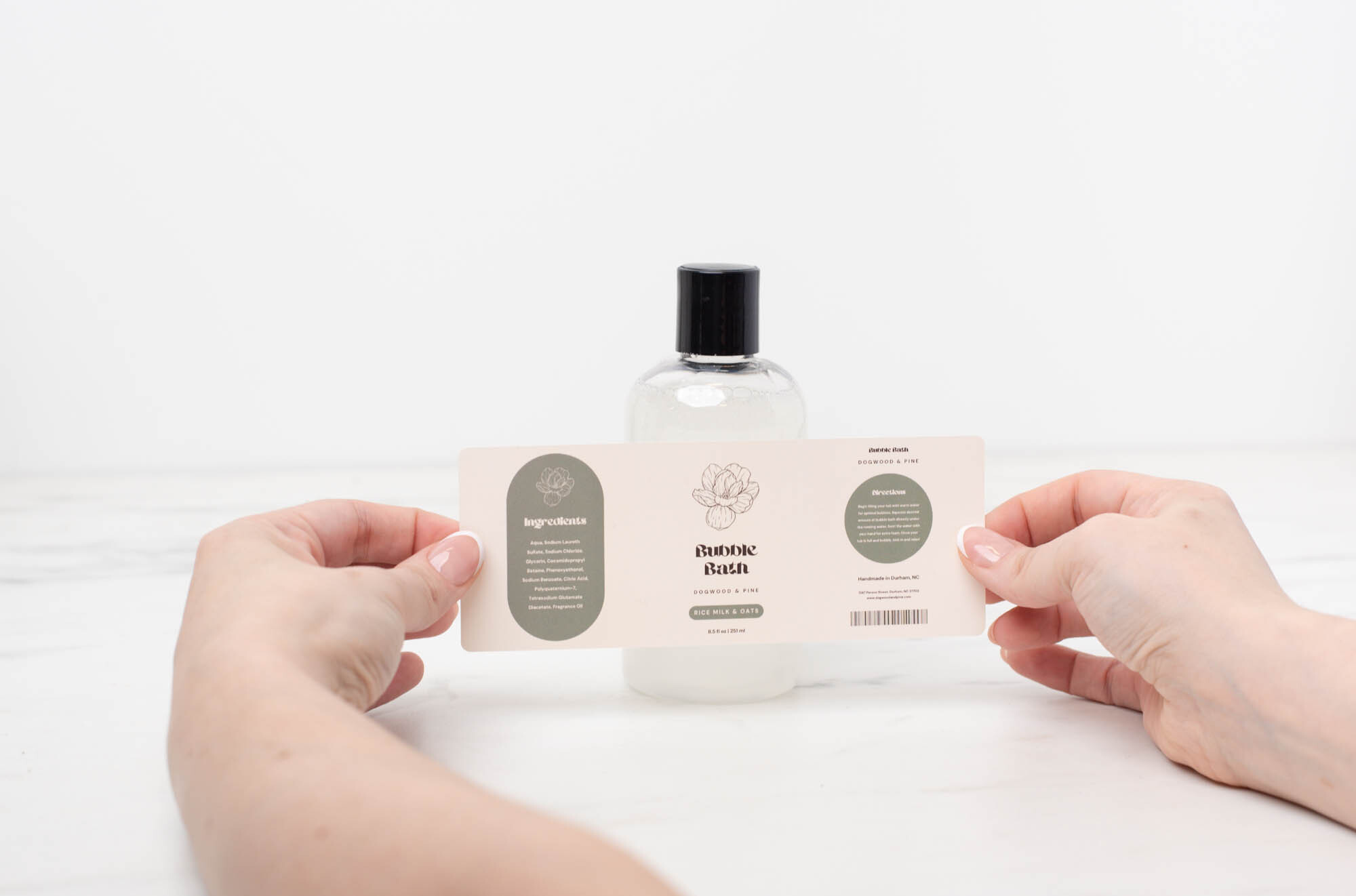 Placing a decorative label on the front of a finished reed diffuser.