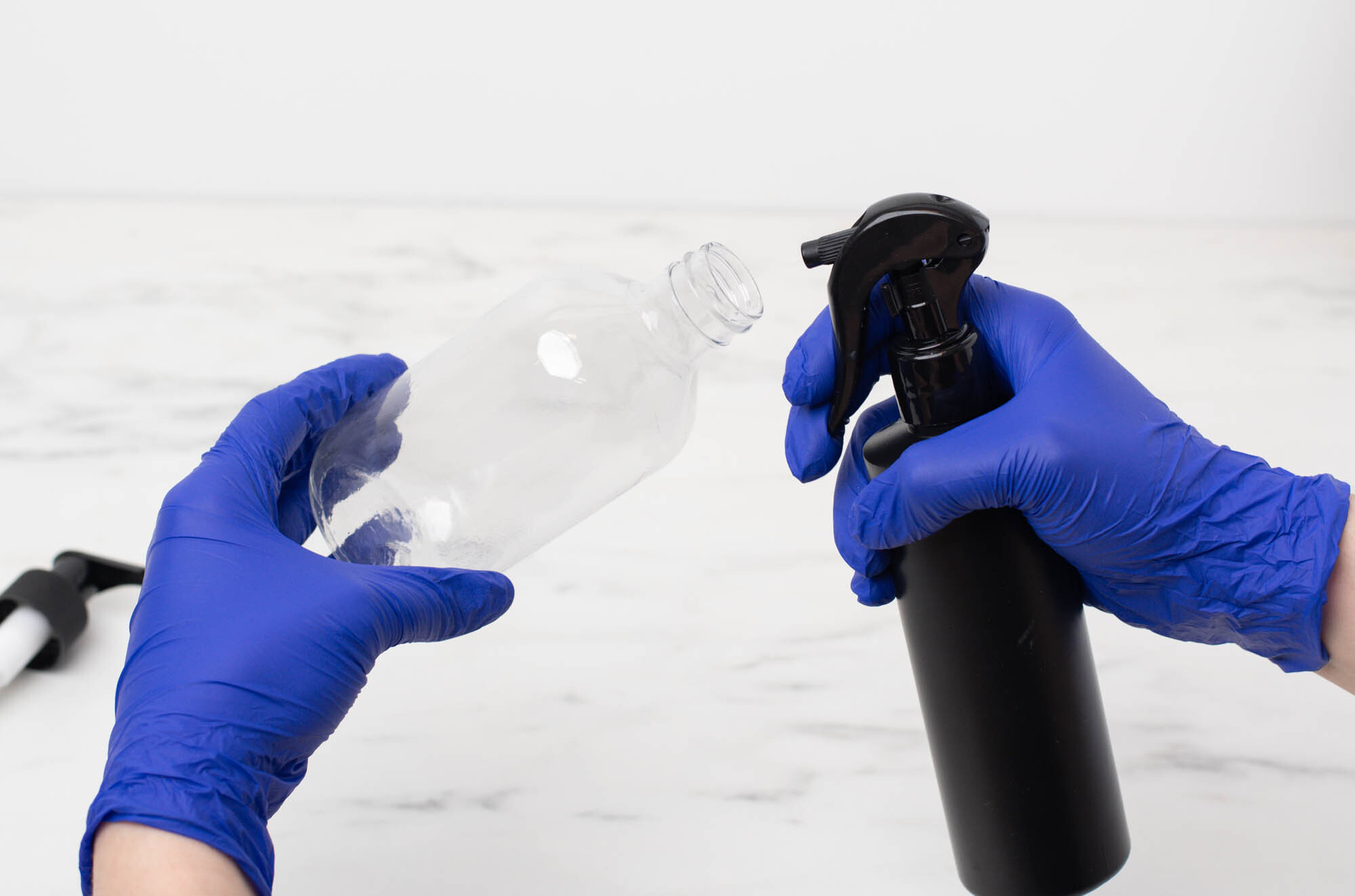 Spraying rubbing alcohol into an empty lotion bottle.