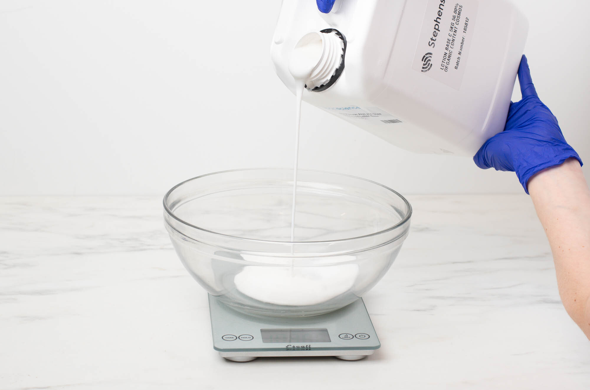 Diffuser base in a funnel pouring pitcher on a scale reading 4.5 ounces.