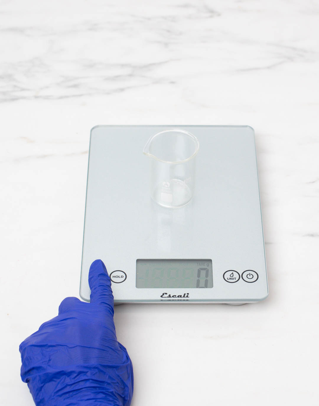 Diffuser base and fragrance mixture in a pouring pitcher on a scale reading 6 ounces. 