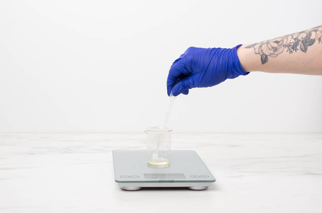 Finger pointing to fluid ounce measurement of mixture in a pouring pitcher. 
