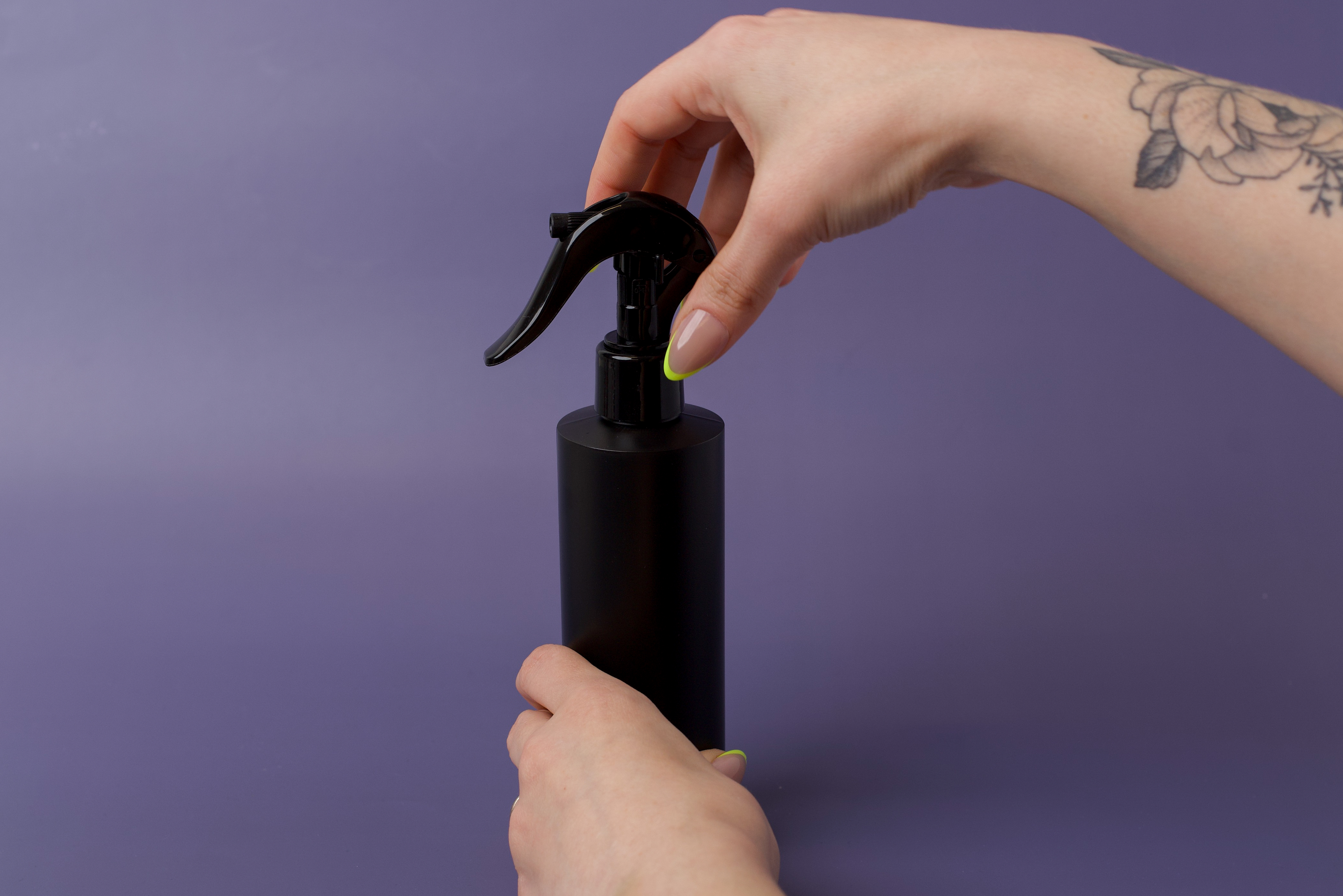 Twisting a spray head onto the bottle.