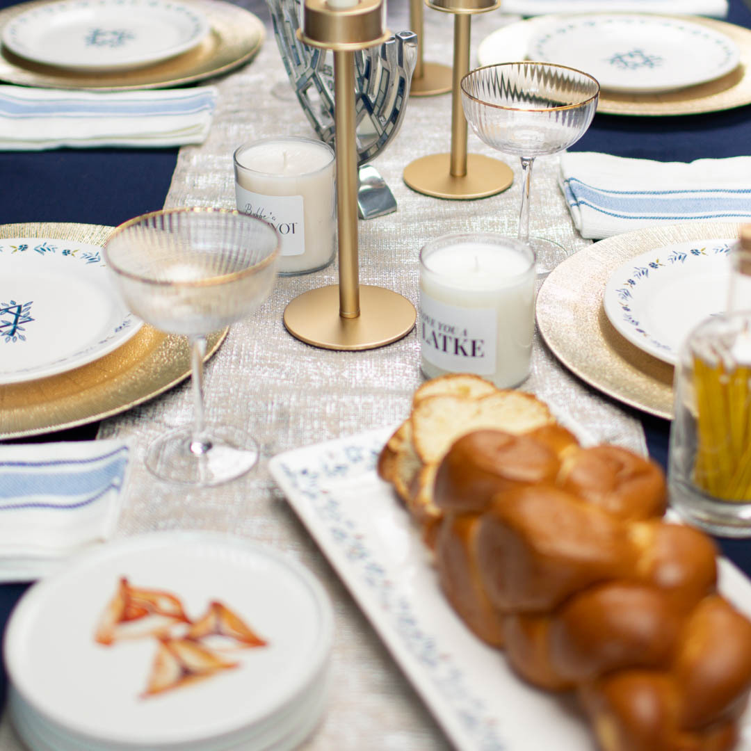 Hanukkah table setting with bread, food, and candles.