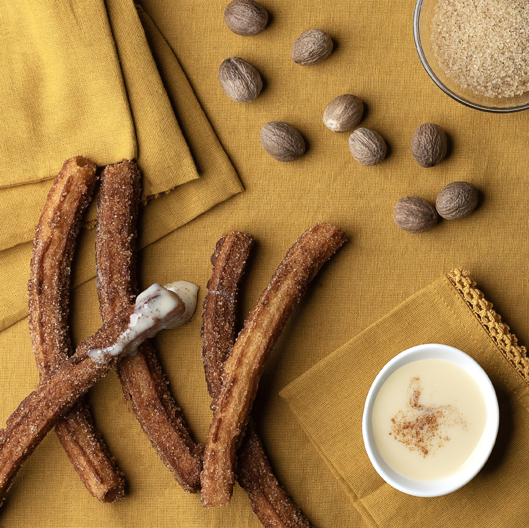 Top down view of rice, cardamom, and star anise on gray fabric.