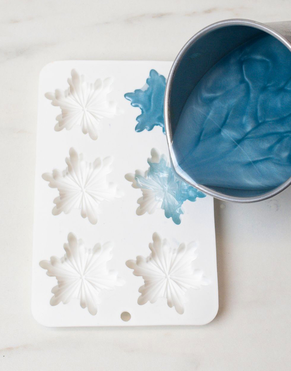 Pouring dyed beeswax into silicone mold.